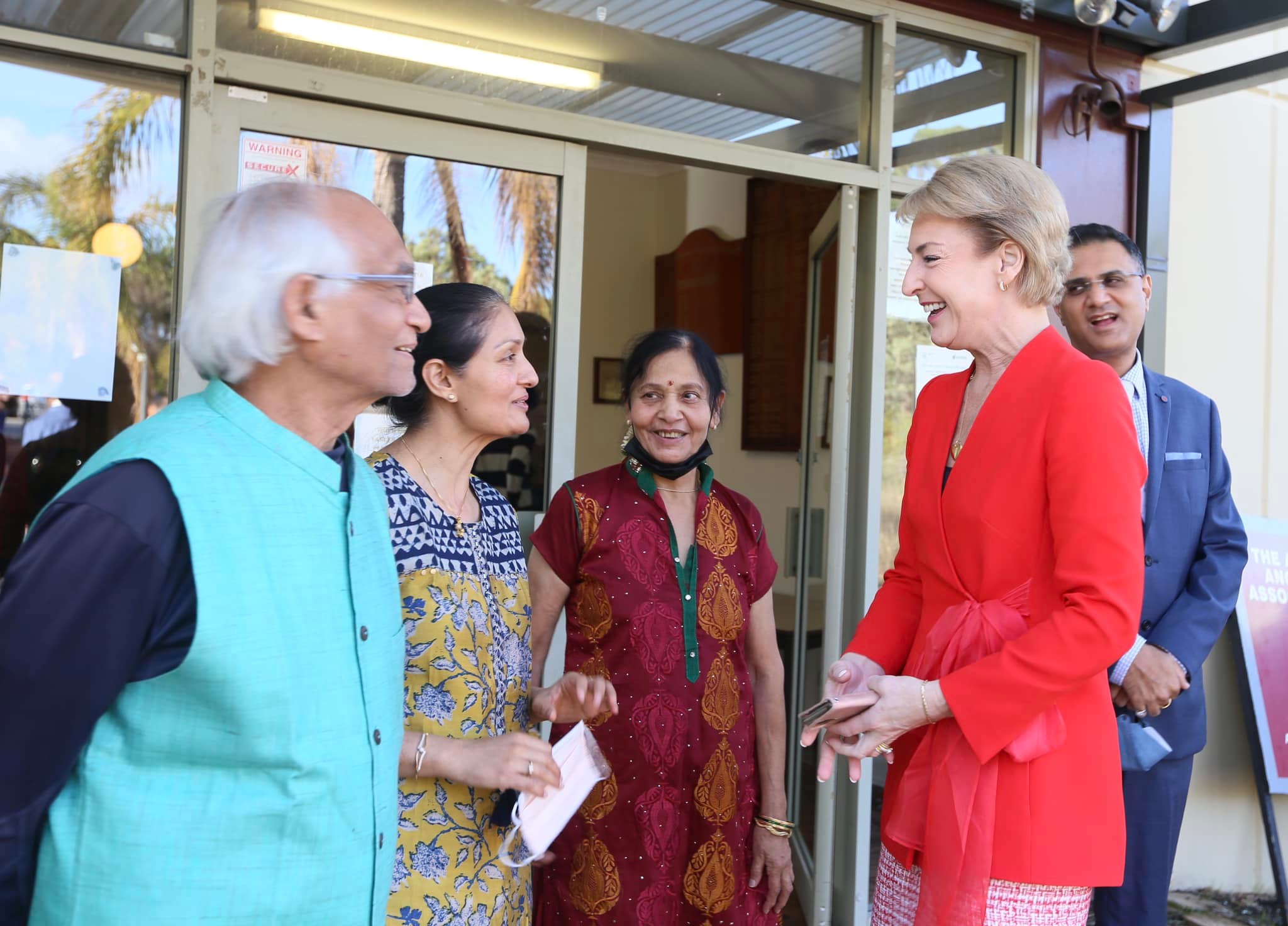 Michaelia Cash smiling while speaking with community members outside a local venue.