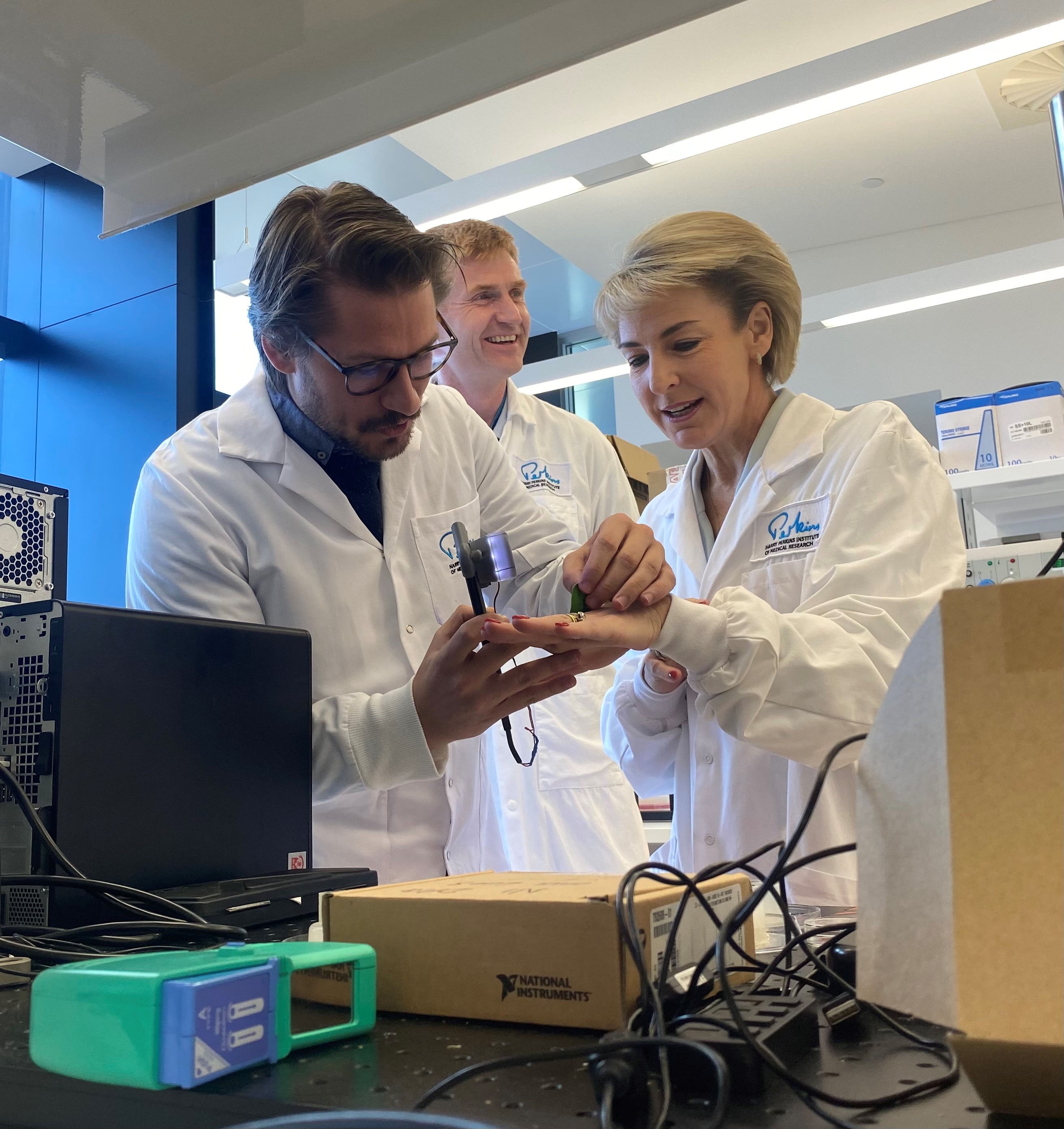 Michaelia Cash listening to medical researchers during a laboratory tour.